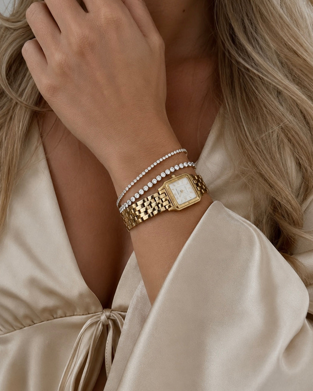 Oraya tennisarmbånd i forgyldt stål i et armstack